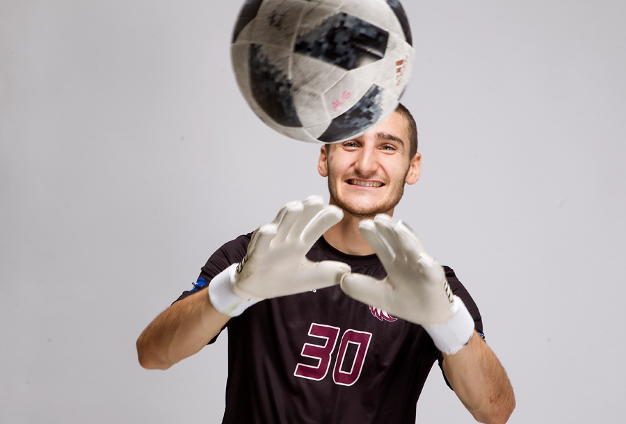 Soccer Goalie catches the ball with his new addias jersey on